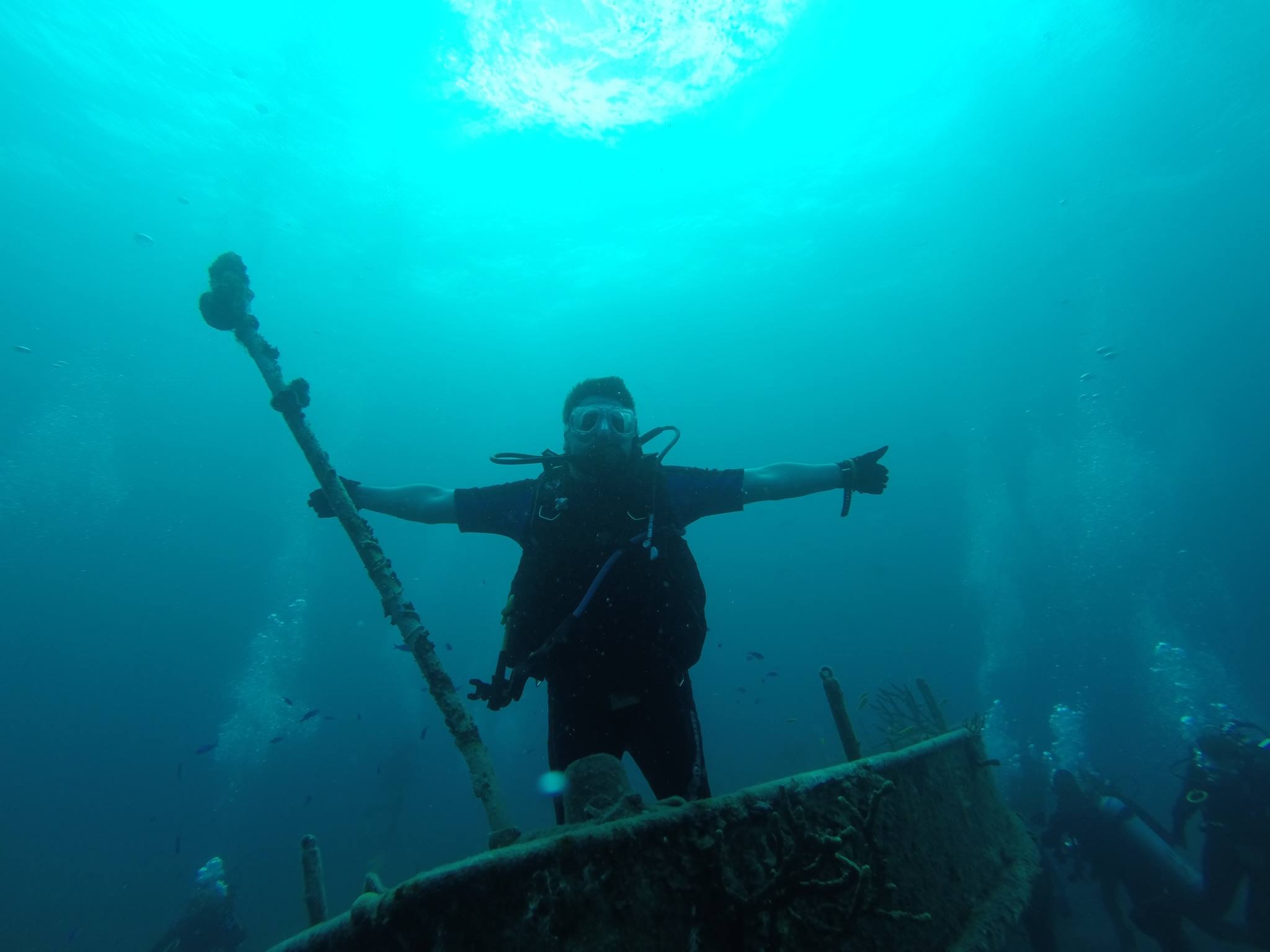 An NSF ocean scientist in the field - scuba diving underwater near a submerged shipwreck